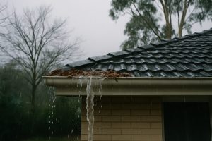 Rain overflowing a blocked gutter on a Melbourne house in winter